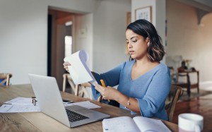 Woman carefully reading through a contract while in her home office